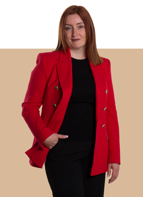 Esther Cuerda abogada de pie con chaqueta roja y mano en el bolsillo